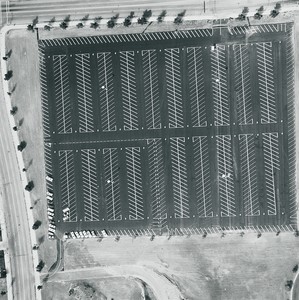 Ed Ruscha, Century City, 1800 Avenue of the Stars, 1967/1999, from the portfolio Parking Lots. Gelatin silver print held in place with acetate corners to mat board, 20 × 16 inches (50.8 × 40.6 cm); image size: 15 ½ × 15 ½ inches (39.4 × 39.4 cm); window mat: 24 × 24 inches (61 × 61 cm), edition of 35 + 11 AP © Ed Ruscha